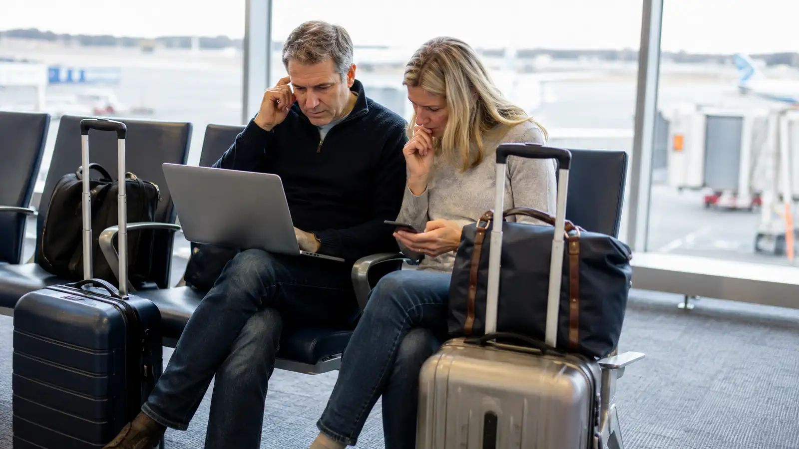 Travellers reviewing alternative flights during an airport disruption