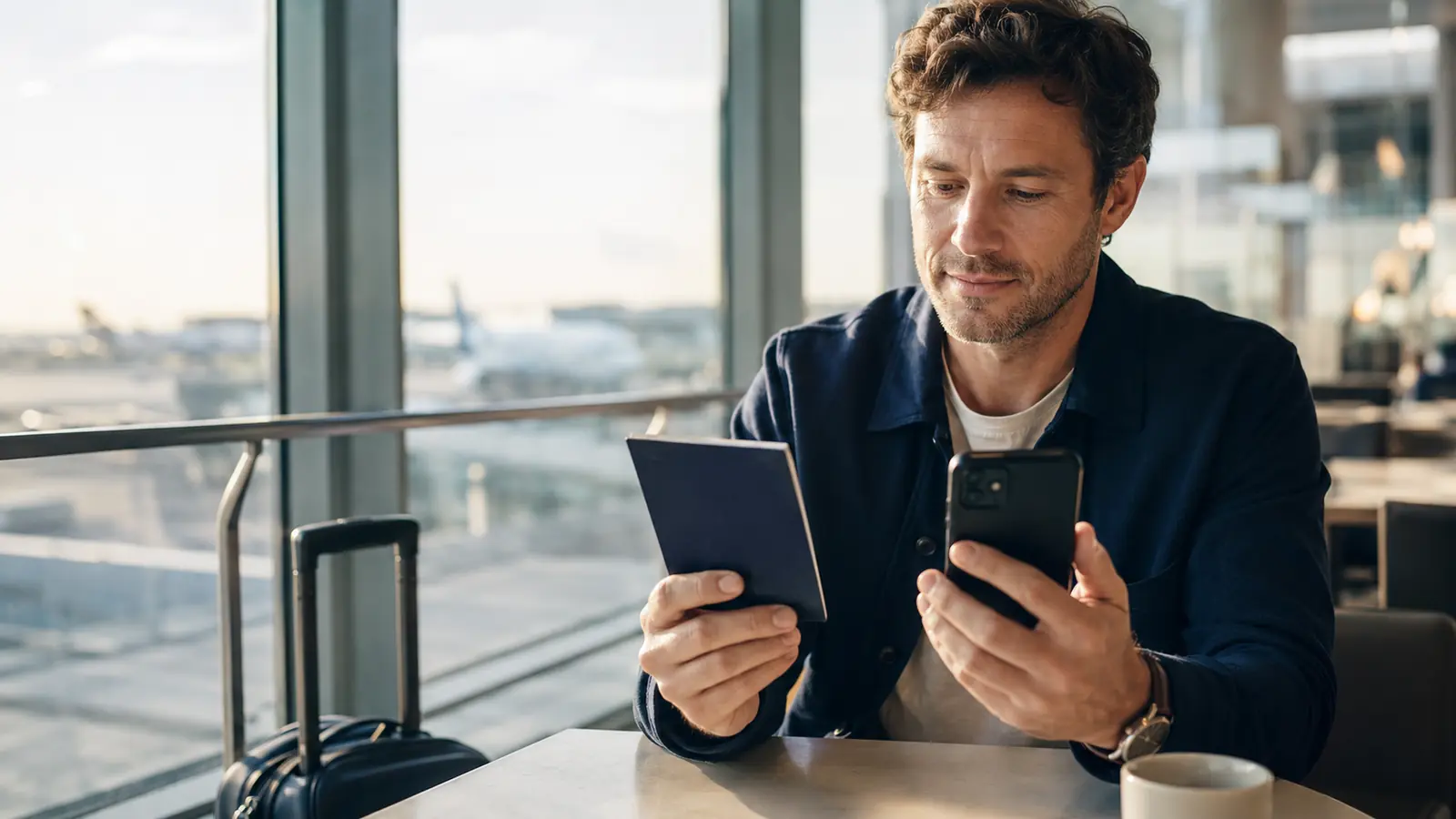 Traveller comparing an e-ticket itinerary with a travel document at an airport